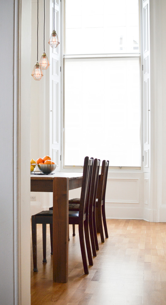 Ispirazione per una piccola sala da pranzo aperta verso il soggiorno contemporanea con pareti bianche, pavimento in legno massello medio e nessun camino