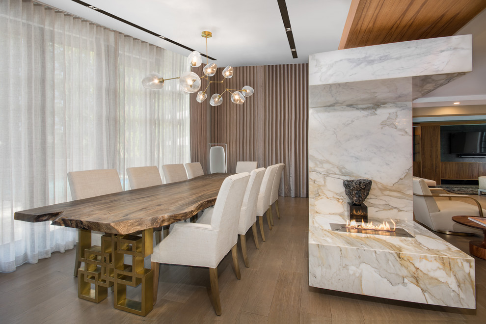 Inspiration for a large contemporary dark wood floor great room remodel in Miami with multicolored walls, a two-sided fireplace and a stone fireplace