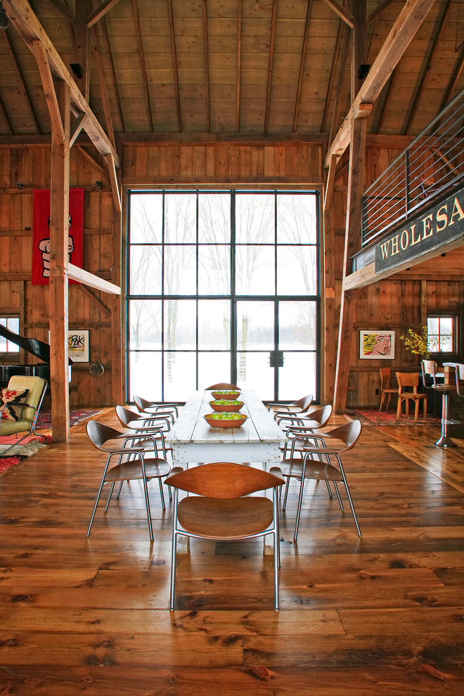 Aménagement d'une salle à manger ouverte sur le salon campagne avec parquet foncé.