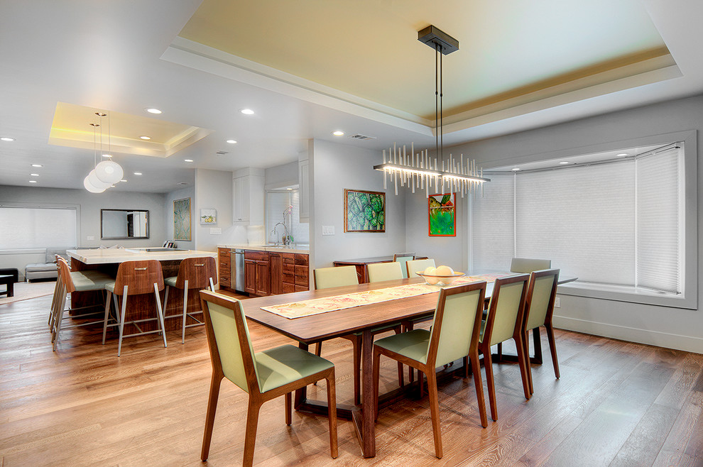 Esempio di una sala da pranzo aperta verso il soggiorno minimalista di medie dimensioni con pareti grigie e pavimento in legno massello medio