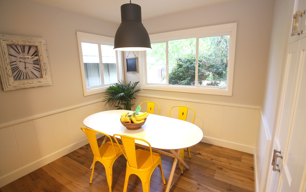 Foto di una sala da pranzo aperta verso la cucina moderna di medie dimensioni con pareti bianche, pavimento in legno massello medio e nessun camino