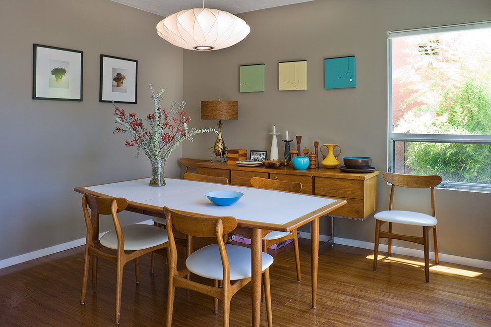 Cette image montre une salle à manger minimaliste avec un mur gris, parquet en bambou et éclairage.