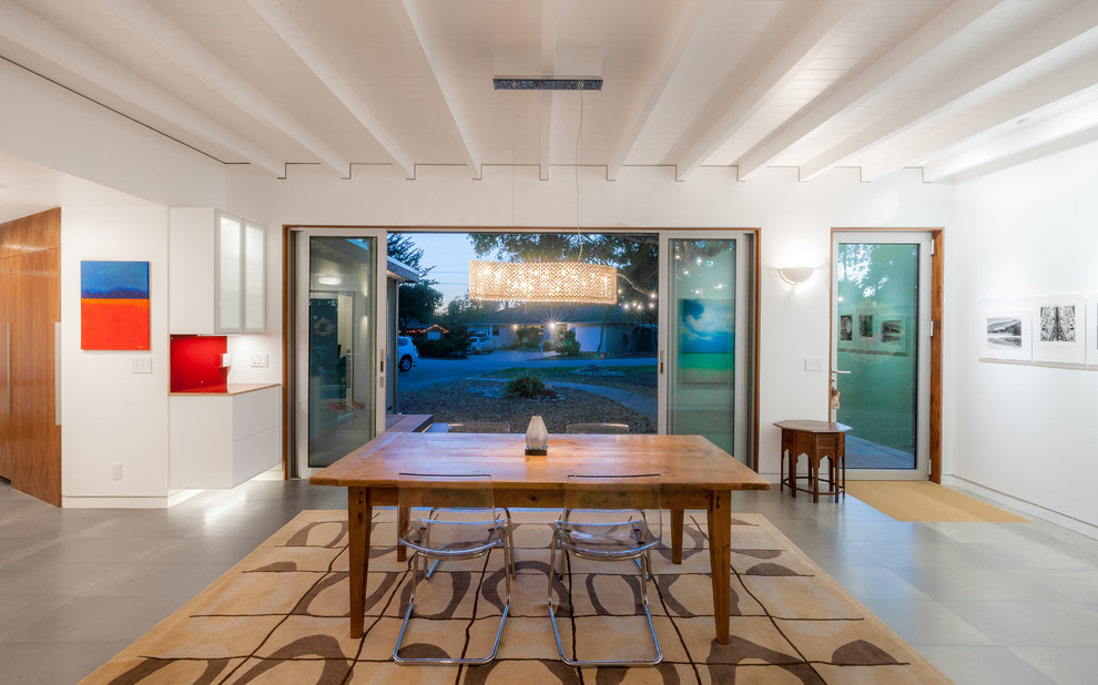 Ispirazione per una sala da pranzo aperta verso il soggiorno minimalista di medie dimensioni con pareti bianche, pavimento con piastrelle in ceramica e nessun camino