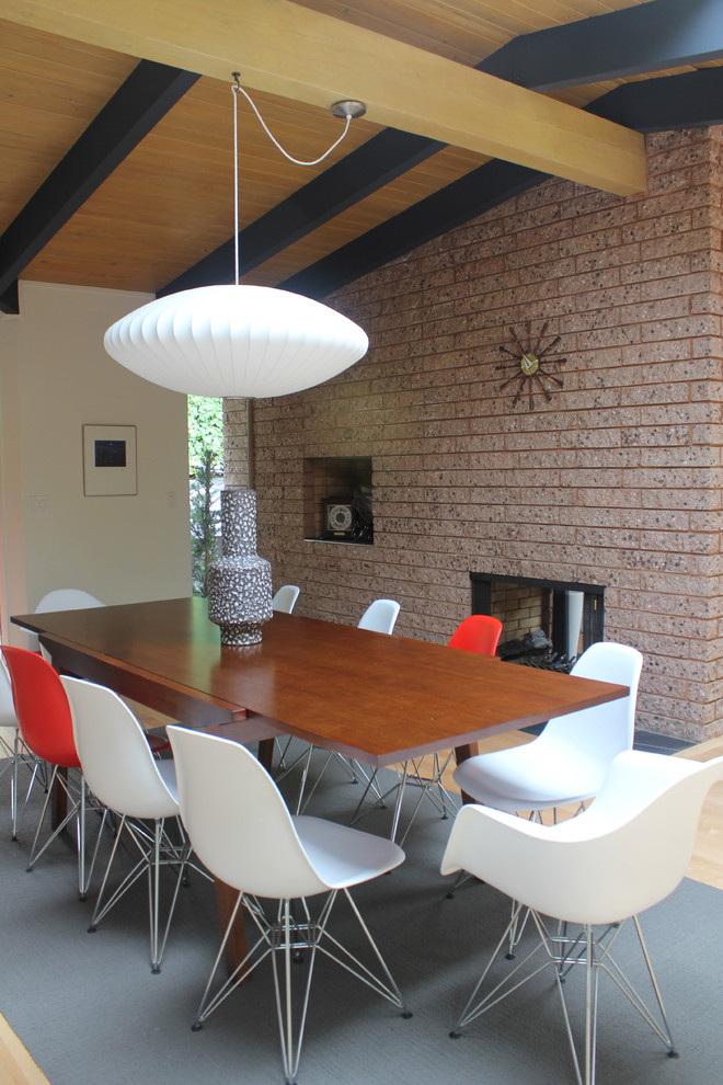 Photo of a modern dining room in San Francisco with a two-sided fireplace.