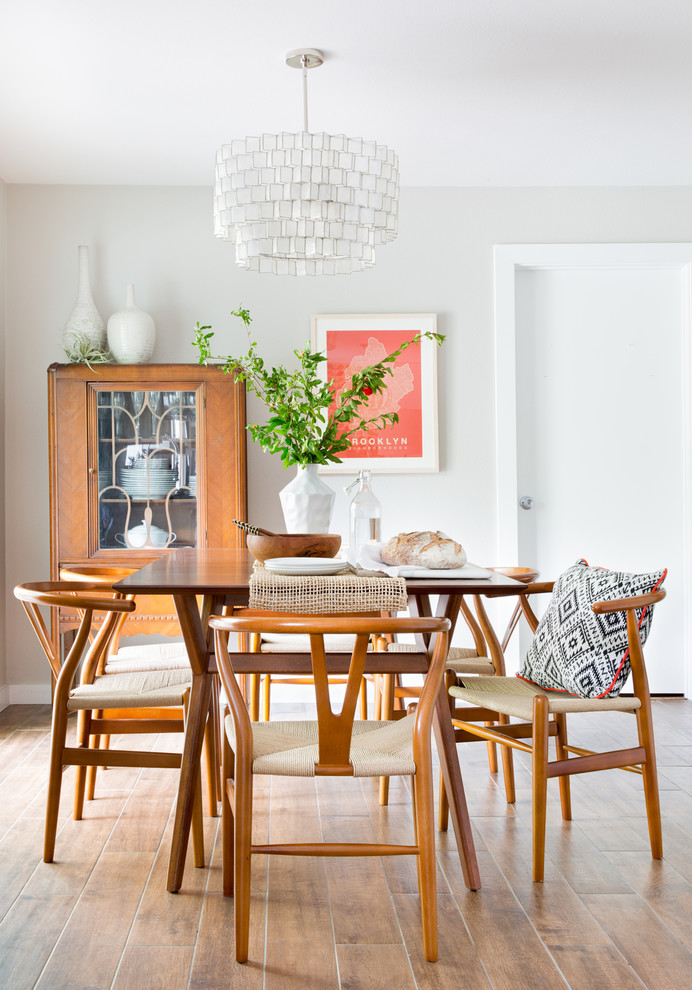 На фото: кухня-столовая среднего размера в стиле ретро с бежевыми стенами, полом из ламината и коричневым полом без камина