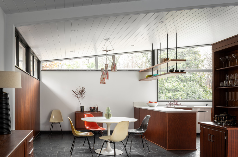 Midcentury open plan dining room in Atlanta with white walls, grey floors and slate flooring.