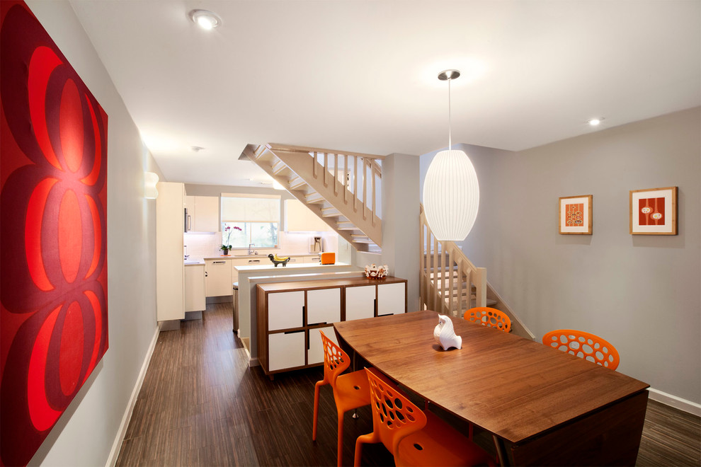 Réalisation d'une salle à manger ouverte sur la cuisine design avec un mur gris et un sol en carrelage de porcelaine.