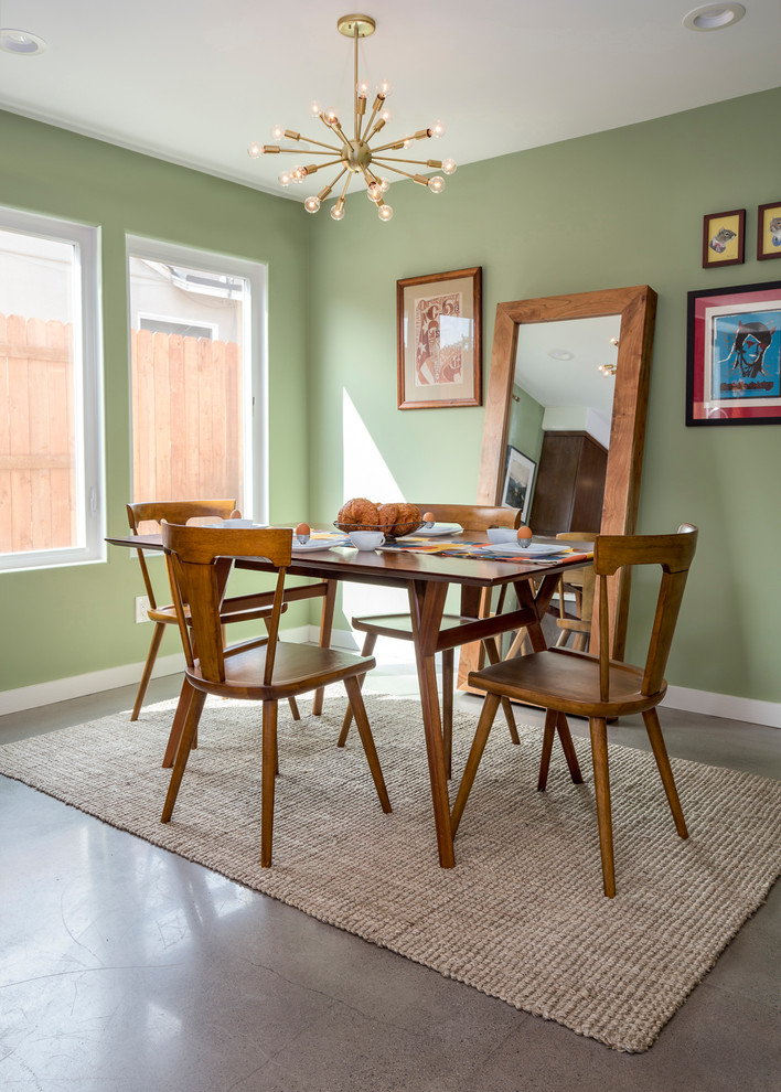 Idee per una piccola sala da pranzo aperta verso la cucina minimalista con pareti verdi, pavimento in cemento, nessun camino e pavimento grigio