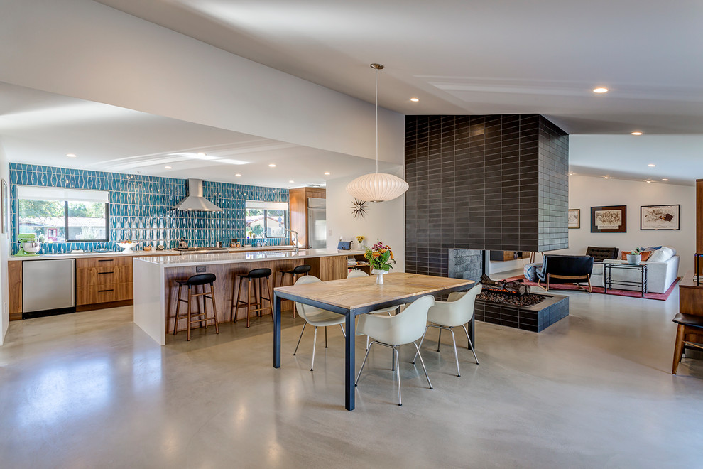 Retro Wohnküche mit Betonboden, gefliester Kaminumrandung, grauem Boden, weißer Wandfarbe und Tunnelkamin in Phoenix