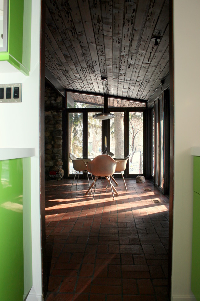 Foto di una sala da pranzo aperta verso il soggiorno moderna di medie dimensioni con pareti marroni, pavimento in mattoni e nessun camino