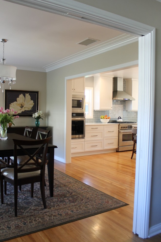 На фото: кухня-столовая среднего размера в стиле неоклассика (современная классика) с зелеными стенами, паркетным полом среднего тона и коричневым полом с