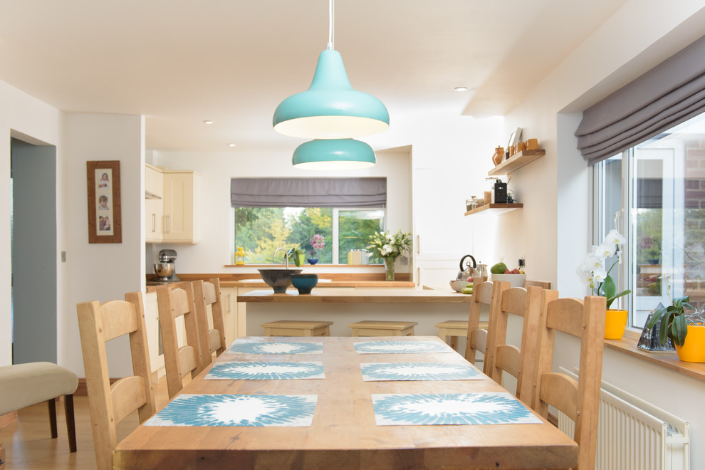 ケンブリッジシャーにある低価格の小さなコンテンポラリースタイルのおしゃれなダイニングキッチン (白い壁、淡色無垢フローリング、暖炉なし) の写真