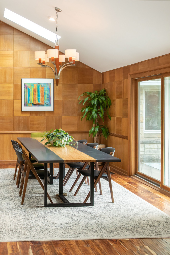 Aménagement d'une salle à manger ouverte sur la cuisine rétro de taille moyenne avec un mur beige, un sol en bois brun, une cheminée ribbon, un manteau de cheminée en béton et un sol marron.