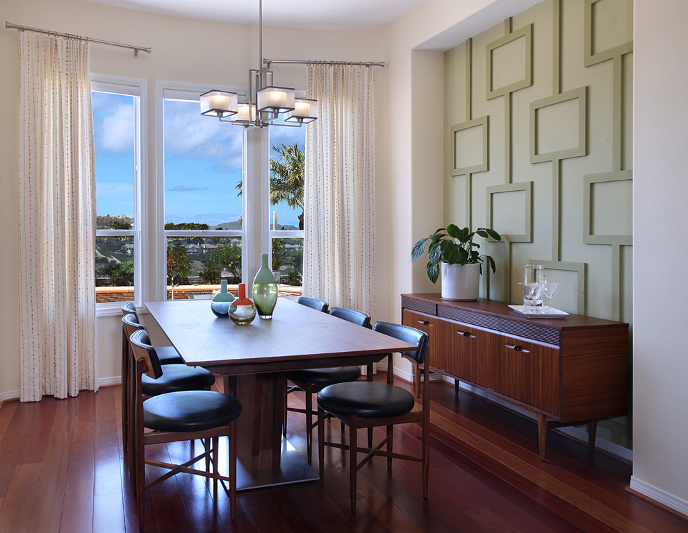 Medium sized midcentury dining room in Orange County with green walls and medium hardwood flooring.
