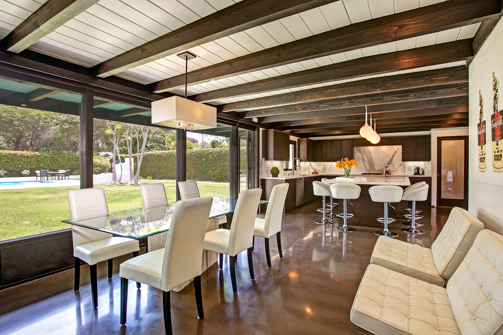 Exemple d'une salle à manger ouverte sur la cuisine rétro avec un mur beige et sol en béton ciré.