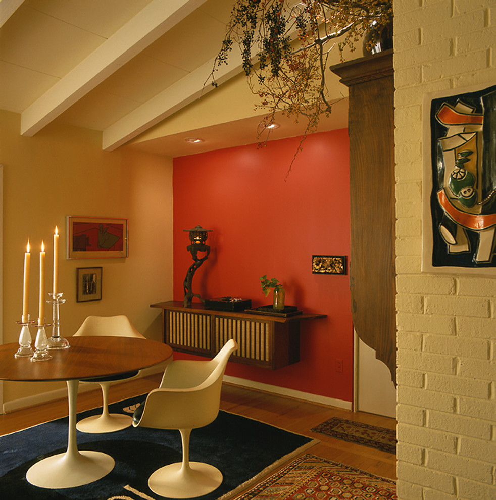 Идея дизайна: столовая в стиле ретро с красными стенами и темным паркетным полом