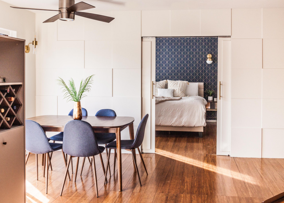 Mittelgroße Moderne Wohnküche mit weißer Wandfarbe, braunem Holzboden, braunem Boden und Wandpaneelen in Los Angeles