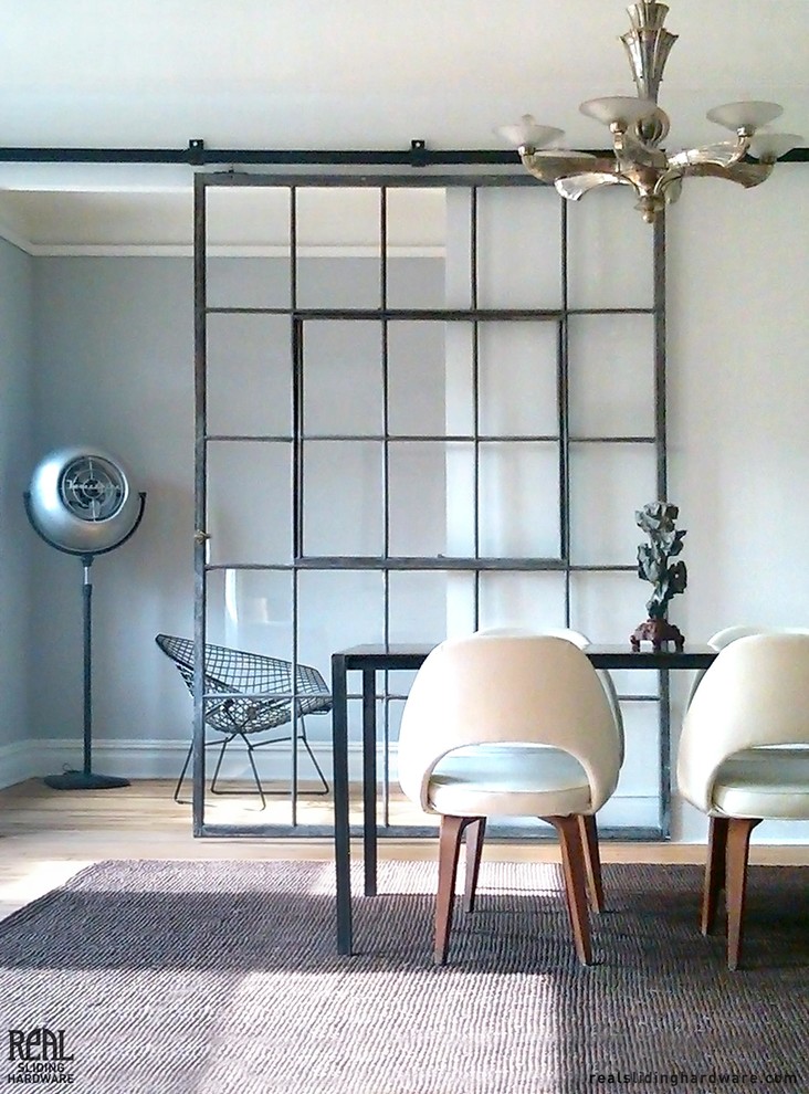 Imagen de comedor urbano de tamaño medio cerrado con paredes grises y suelo de madera clara