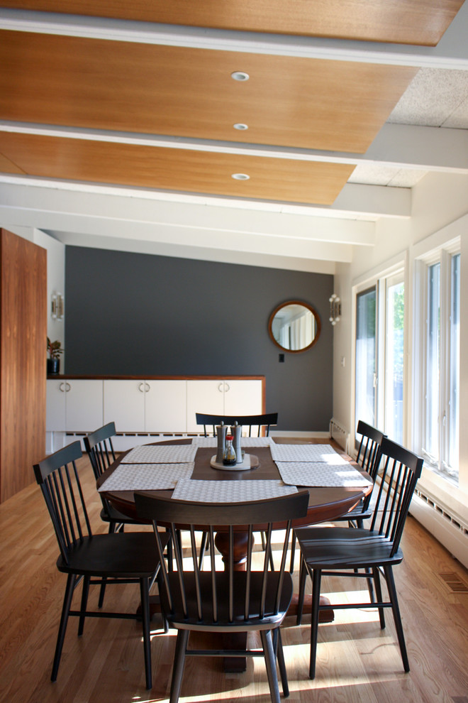 Diseño de comedor retro cerrado con paredes blancas, suelo de madera en tonos medios y suelo marrón