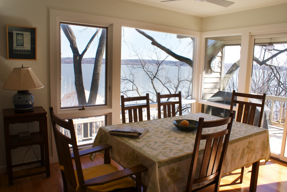 Immagine di una sala da pranzo aperta verso la cucina design con pareti bianche e pavimento in legno massello medio
