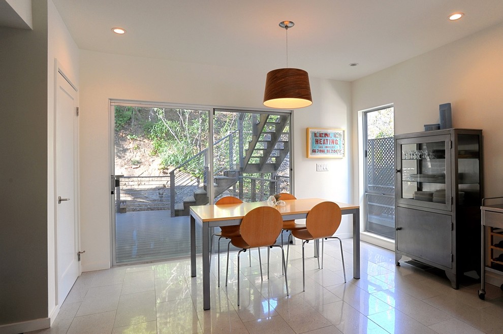 Exemple d'une salle à manger tendance avec un mur blanc.