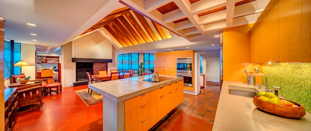 Cette image montre une grande cuisine américaine design avec sol en béton ciré.