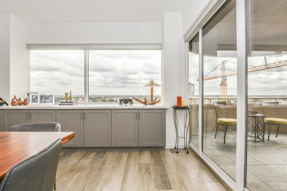 Immagine di una sala da pranzo aperta verso il soggiorno minimalista di medie dimensioni con pareti bianche, pavimento in gres porcellanato e pavimento beige