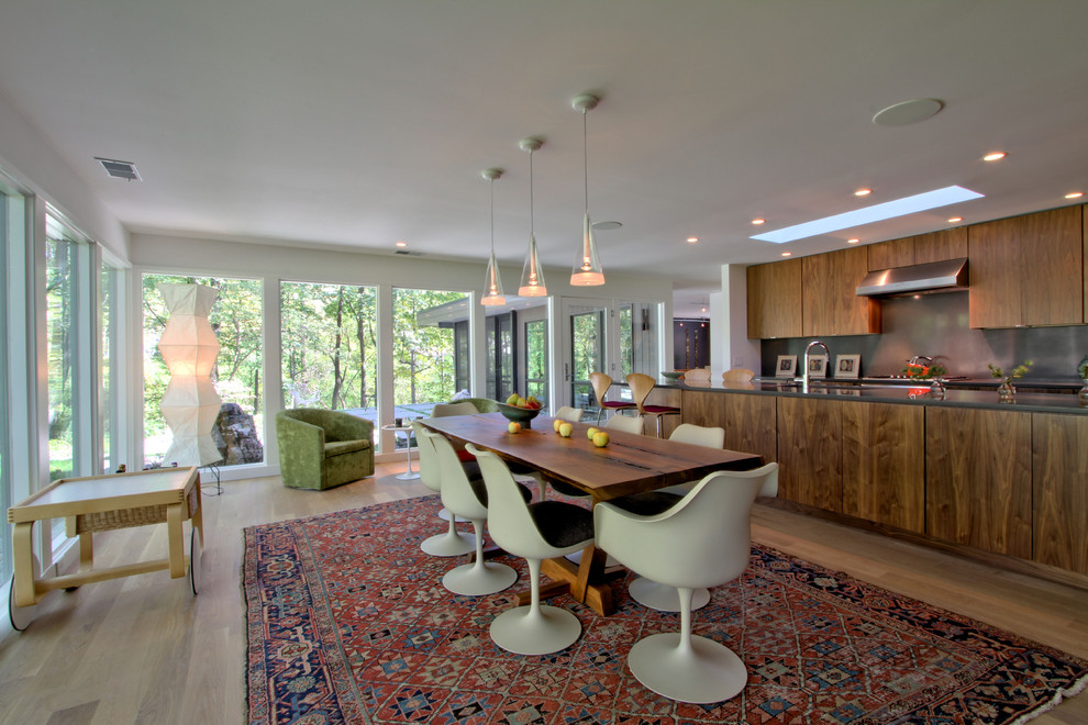 This is an example of a medium sized midcentury open plan dining room in Indianapolis with white walls, light hardwood flooring, beige floors and feature lighting.
