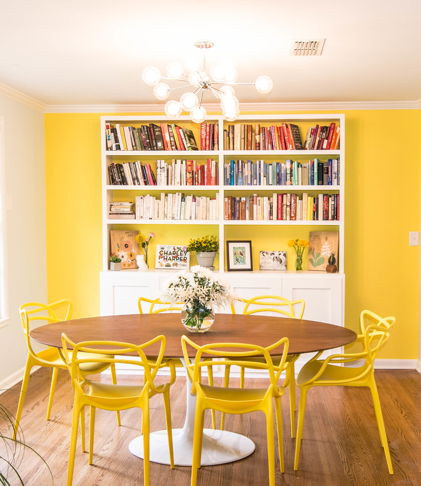 Idées déco pour une salle à manger rétro avec un mur jaune, parquet foncé et un sol marron.