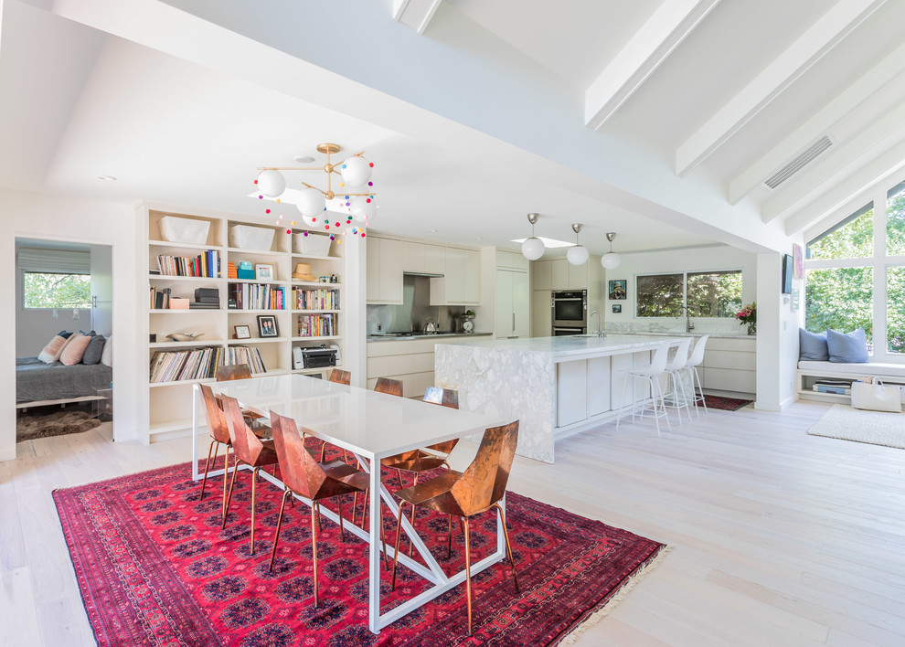 Cette photo montre une salle à manger ouverte sur le salon rétro avec un mur blanc, parquet clair et un sol beige.