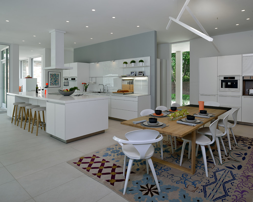 Aménagement d'une salle à manger ouverte sur la cuisine contemporaine avec un mur gris et un sol blanc.
