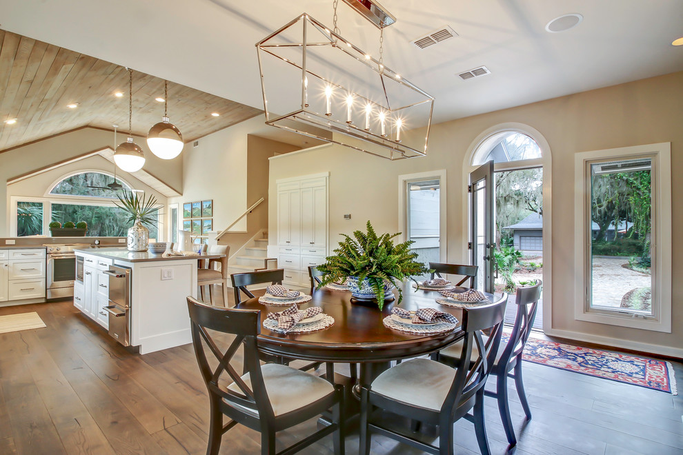 Exemple d'une salle à manger ouverte sur la cuisine chic de taille moyenne avec un mur gris et un sol en bois brun.