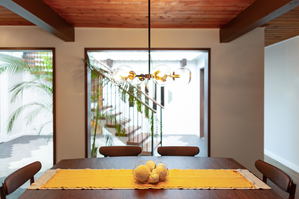 Idee per una sala da pranzo aperta verso la cucina minimalista di medie dimensioni con pareti grigie, pavimento in legno massello medio, nessun camino e pavimento marrone