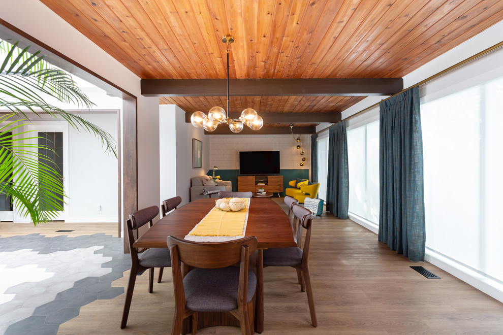 На фото: гостиная-столовая среднего размера в стиле ретро с серыми стенами, паркетным полом среднего тона и коричневым полом без камина