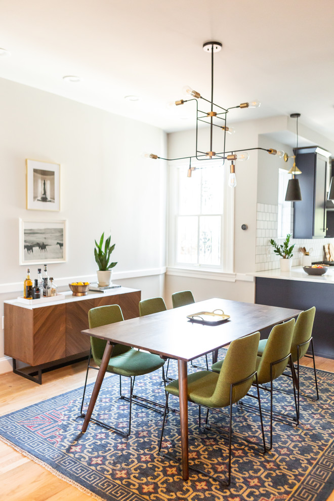 Esempio di una sala da pranzo aperta verso la cucina minimalista di medie dimensioni con pareti bianche, pavimento in legno massello medio, pavimento marrone e nessun camino