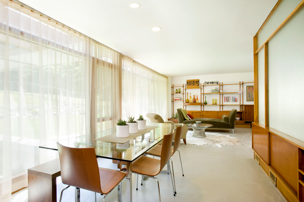 Idée de décoration pour une salle à manger ouverte sur le salon vintage de taille moyenne avec un mur blanc, sol en béton ciré, aucune cheminée et un sol gris.