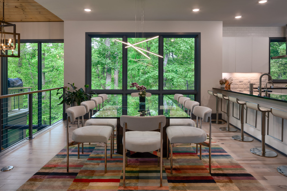 Idee per una sala da pranzo aperta verso la cucina minimal di medie dimensioni con pareti bianche, parquet chiaro e pavimento beige