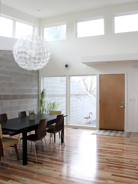 Aménagement d'une salle à manger ouverte sur la cuisine rétro de taille moyenne avec un mur blanc et un sol en bois brun.