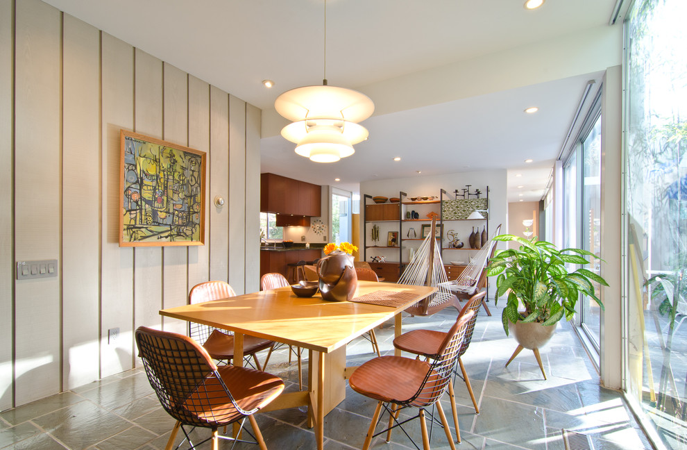 Foto di una sala da pranzo aperta verso la cucina minimalista