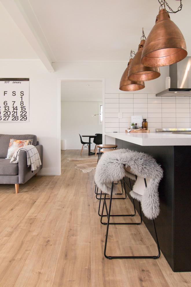 Immagine di una sala da pranzo aperta verso la cucina minimalista di medie dimensioni con pareti bianche, pavimento in laminato, pavimento beige e nessun camino