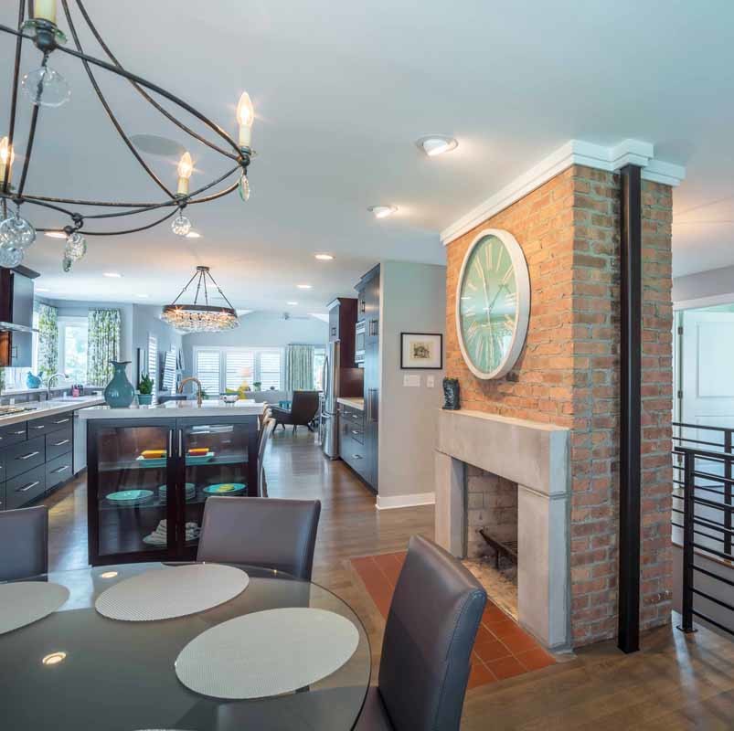 Cette photo montre une salle à manger ouverte sur la cuisine tendance de taille moyenne avec un mur gris, un sol en bois brun, une cheminée standard, un manteau de cheminée en brique, un sol marron, un plafond en papier peint et du papier peint.