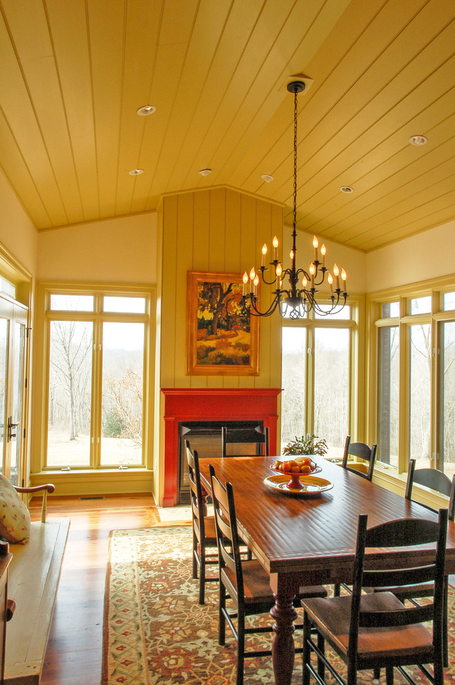 Country medium tone wood floor dining room photo in DC Metro with beige walls, a standard fireplace and a wood fireplace surround