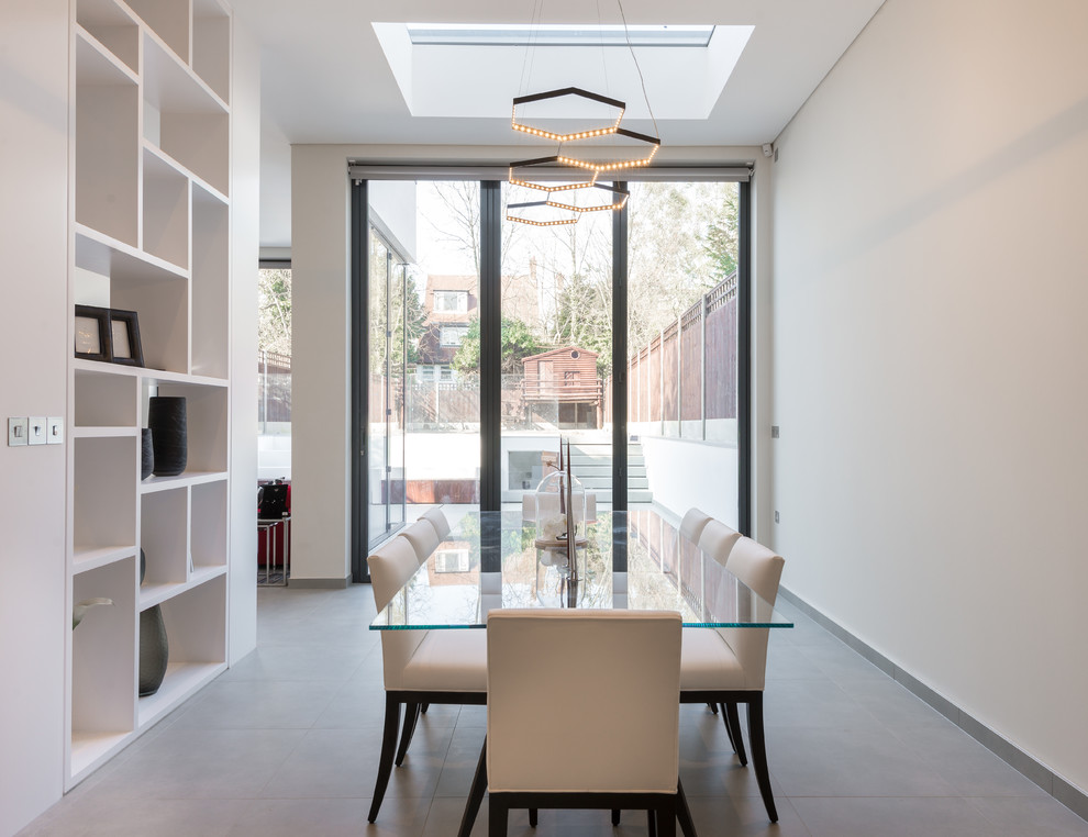 Idee per una sala da pranzo aperta verso la cucina contemporanea di medie dimensioni con pareti bianche, pavimento in gres porcellanato e pavimento grigio