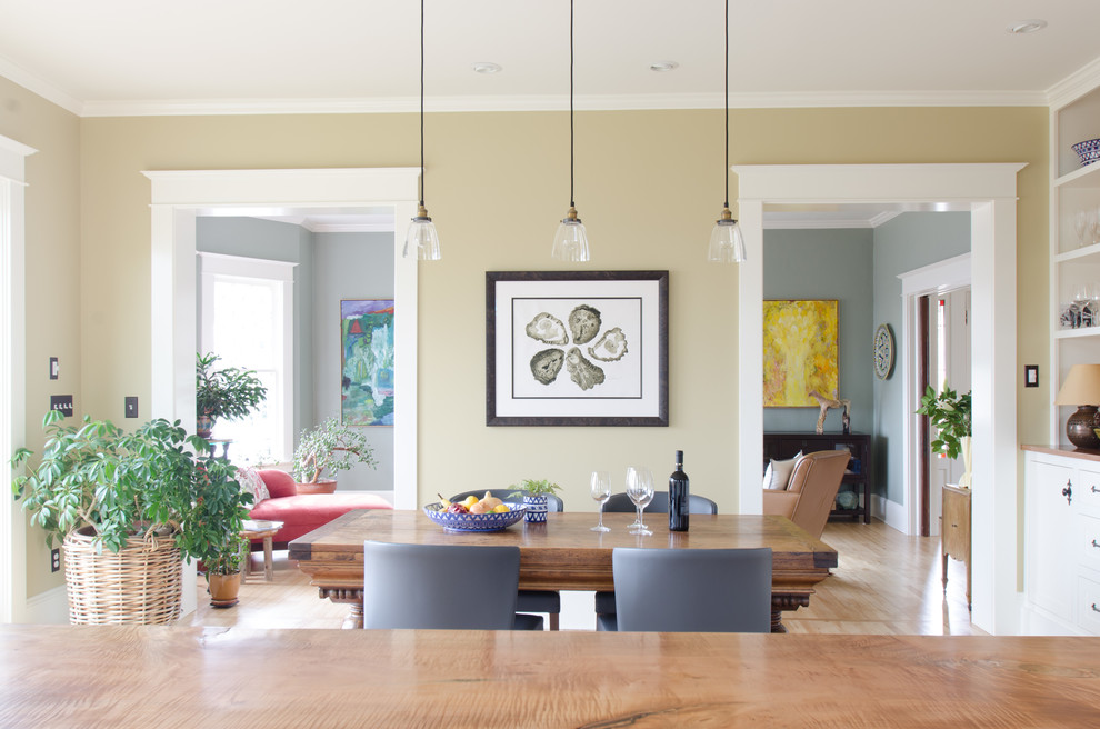 This is an example of a classic kitchen/dining room in Portland with beige walls and light hardwood flooring.