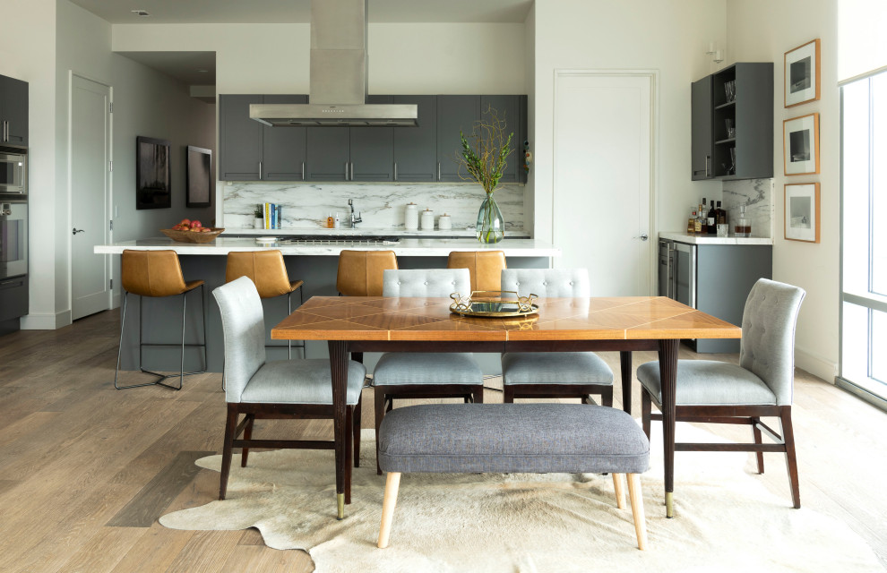 На фото: кухня-столовая в стиле неоклассика (современная классика) с белыми стенами, паркетным полом среднего тона и коричневым полом без камина