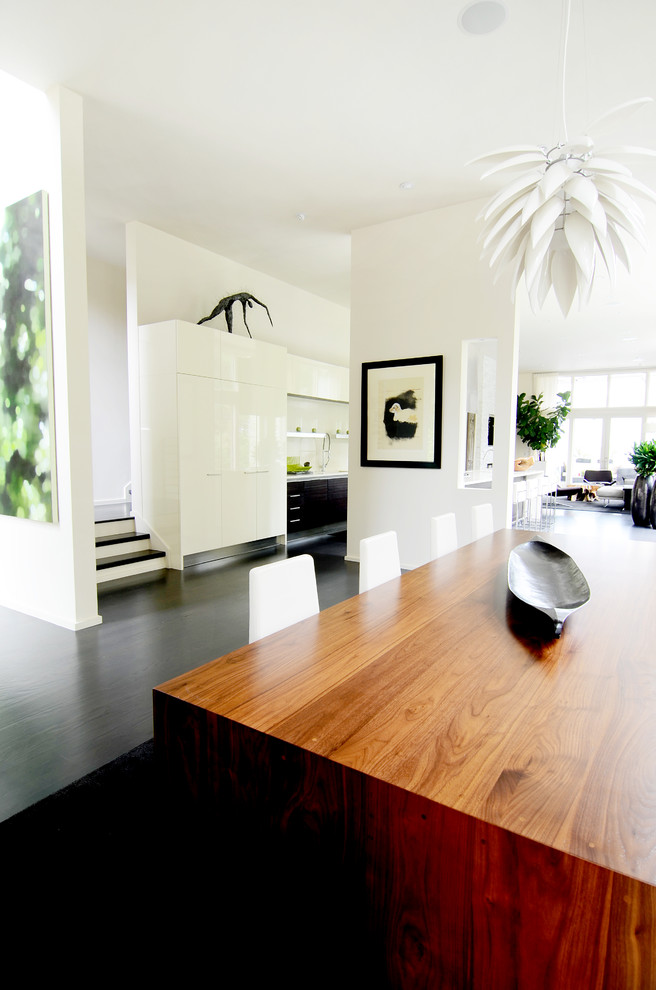Пример оригинального дизайна: гостиная-столовая в современном стиле с белыми стенами и темным паркетным полом