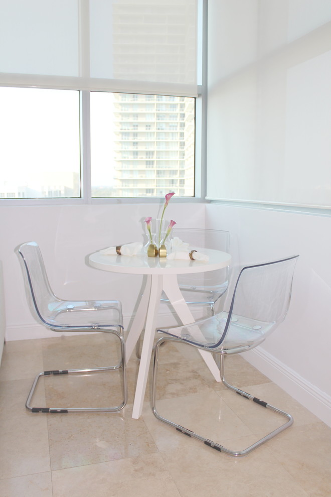 Dining room - small modern travertine floor dining room idea in Miami with white walls