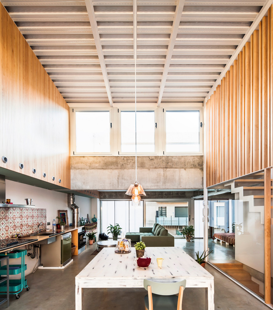 Ispirazione per un'ampia sala da pranzo aperta verso il soggiorno minimal con nessun camino e pavimento in cemento
