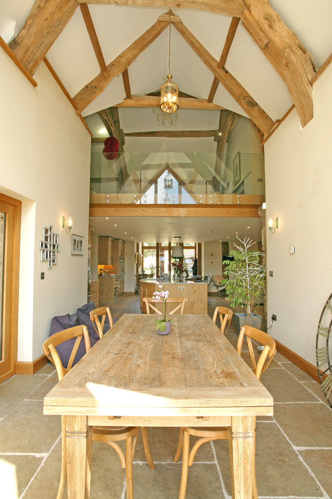 Esempio di una sala da pranzo aperta verso la cucina country con pareti bianche e pavimento in pietra calcarea