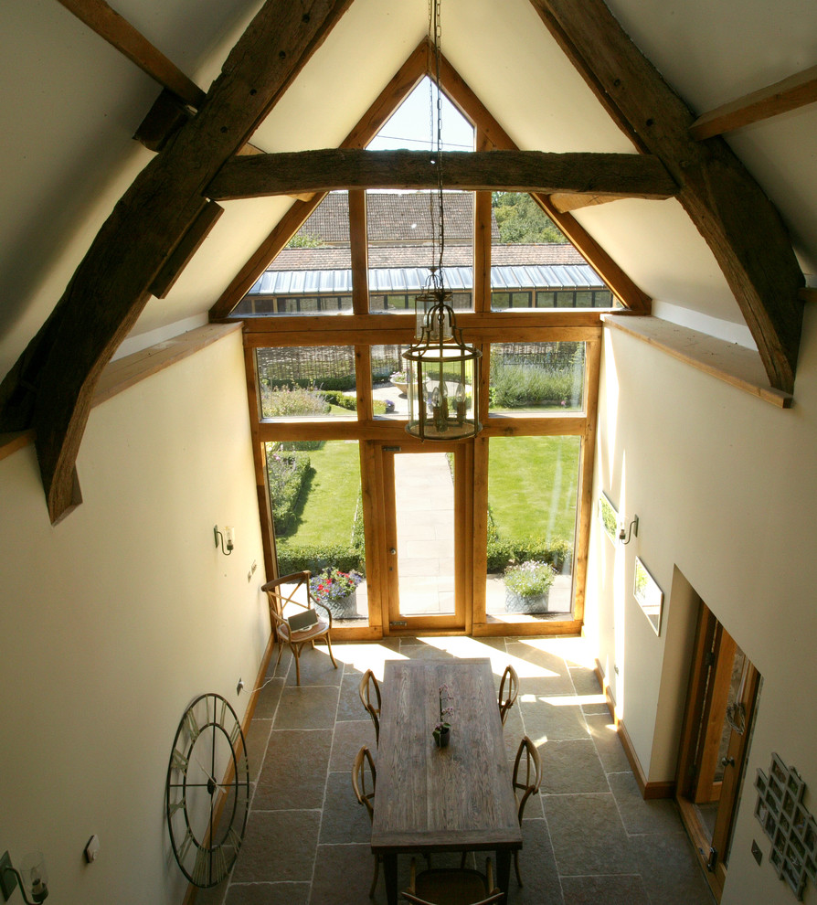 This is an example of a rural dining room in Dorset with white walls.